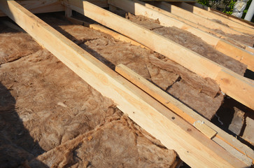 Insulating with Mineral Rock Wool Attic Roof. Close up on insulation layers of mineral wool insulation, house roof insulation