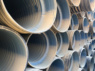 Stacked corrugated pvc-pipes at the outdoor warehouse. Drainage, plumbing, stormwater equipment