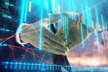 Double exposure of financial chart on cityscape background with two businessmen handshake. Concept of financial analysis and investment opportunities