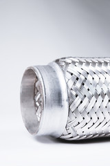 Full-contrast image flexible connection to the exhaust system of a passenger car on a gray gradient background. The concept of new car parts