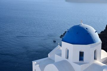 Fototapeta na wymiar Blue and white church and Aegean Sea on Santorini island, Greece