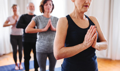 Obraz premium Group of senior people doing yoga exercise in community center club.
