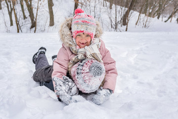 Happy children have fun playing in a snowdrift outdoors in winter.