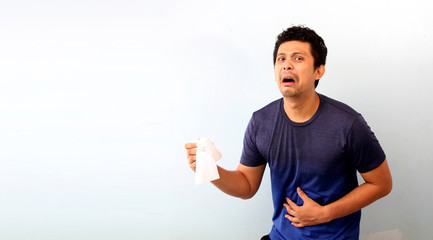 Young  Asaia man holding a single roll of toilet paper isolated on white background with copy space.