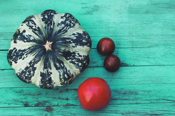 Still life with august harvest. Squash and tomatoes on vintage wooden background. The concept of...