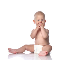 Infant child baby boy toddler sitting in diaper happy smiling eating hands playing isolated on white