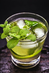 Mojito cocktail on dark wood table. With space for your text, typical Cuban drink, known worldwide.