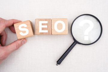 Businessman hand arranging wood block stacking with icon seo.