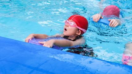kid learn how to swim in swimming class