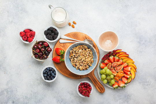Gluten and grain free paleo granola or muesli made from nuts. Fruit berries platter, strawberries blueberries raspberries peach figs red currant, almond milk, top view, selective focus