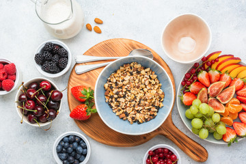 Gluten free and grain free paleo granola or muesli made from nuts. Fruit berries platter, strawberries blueberries raspberries peach figs red currant, top view, selective focus