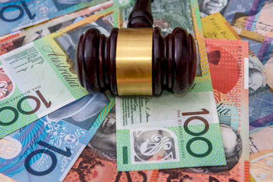 Wooden judge's gavel on colorful australian dollars
