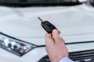 Dealer holding keys from new car close up