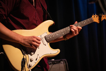 Obraz na płótnie Canvas Male guitarist playing an electric stratocaster guitar on a gig