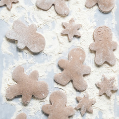 Gingerbread cookies in flour for Christmas baking concept.