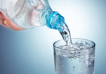 puring water from plastic bottle into glass
