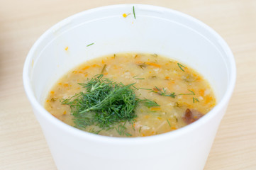 Russian pea soup with bacon in a styrofoam bowl.