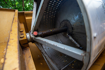 Wine presser in working. Rotary drum and screw press for the vine in winery