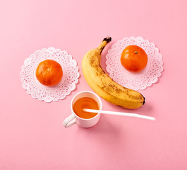 Smile of banana and tangerines on a pink background