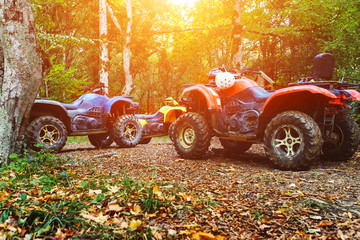 A group of ATVs in a forest covered in mud. Wheels and elements of all-terrain vehicles in mud and...