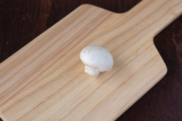 木のカッティングボードの上の白いマッシュルーム