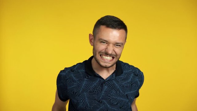 Happy excited man celebrate success isolated on yellow background