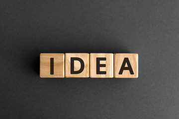 Idea - word from wooden blocks with letters, knowledge or understanding or a suggestion, thought, or plan idea concept,  top view on grey background