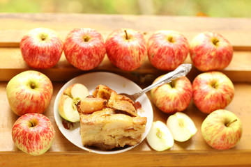 pieces of fresh baked apple pie among raw apples country style still life