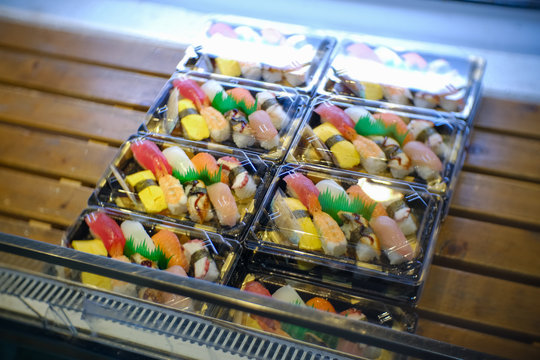 a lot of packs of a variety of sushi such as Tamago egg, salmon, grilled eel and etc places in a freezer