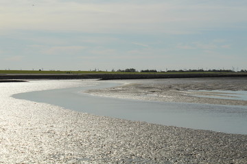 Obraz premium The Wadden Sea near Bensersiel, Northern Germany, at low tide - UNESCO World Heritage Site
