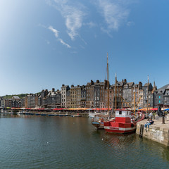 people enjoying a beautiful summer day in the village of Honfleur in Normandy