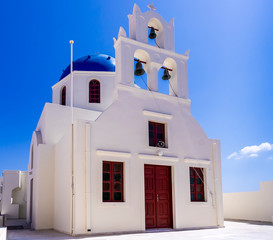 beautifull white greek church with blue dome and bells in Santorini