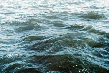 Water surface with ripples and sunlight reflections