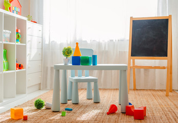 Copy the space of an empty wall in a simple children's room with a white wooden floor and a large and light window.