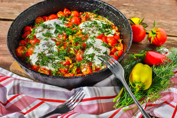 fried eggs with vegetables in a pan