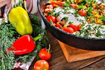 fried eggs with vegetables in a pan