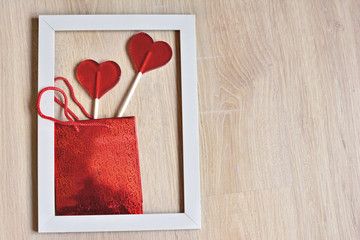 valentines day concept:  box with two heart  shaped lollipops in white frame