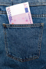 Euro banknotes in jeans back pocket. Forgotten money, nest egg. Concept of saving or spending money. Euro bills falling out. Easy for pickpocket thief to steal the money.