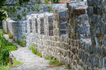 Fototapeta na wymiar stone wall of a medieval fortress with openings for passage and shooting