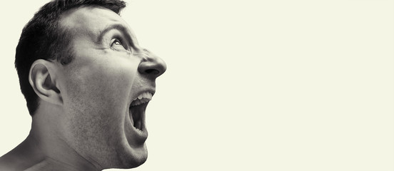 Concept of anger. Portrait of a screaming man on isolated background with free space. Black and white image.