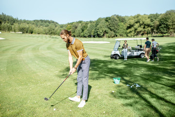 Man playing golf, swinging with putter on a beautiful course on a sunny day
