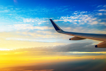 View  of plane wing and beautiful sky  above the clouds from plane 