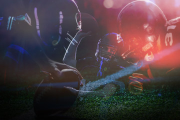 Football player with a black uniform on his knees on a stadium