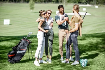 Gordijnen Young elegant friends meeting on the golf course before the play, having fun together on a sunny day © rh2010