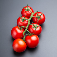 Beautiful red tomatoes on a black background, close up.