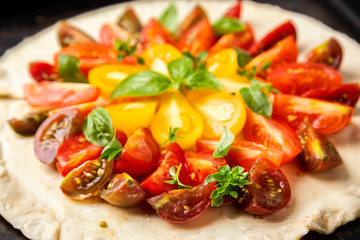 Summer cake with cherry tomatoes, brie cheese and basil. Baking dough with vegetables, greens.