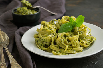 traditional Italian dish. pasta with pesto. on dark background.