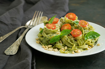 traditional Italian dish. pasta with pesto. on dark background.