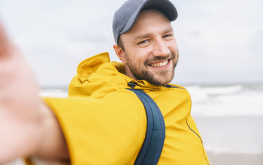cheerful bearded young man solo traveler taking selfie at the beach - Adventure wanderlust concept on the beach 