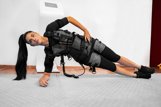Girl in ems suit doing side plank 